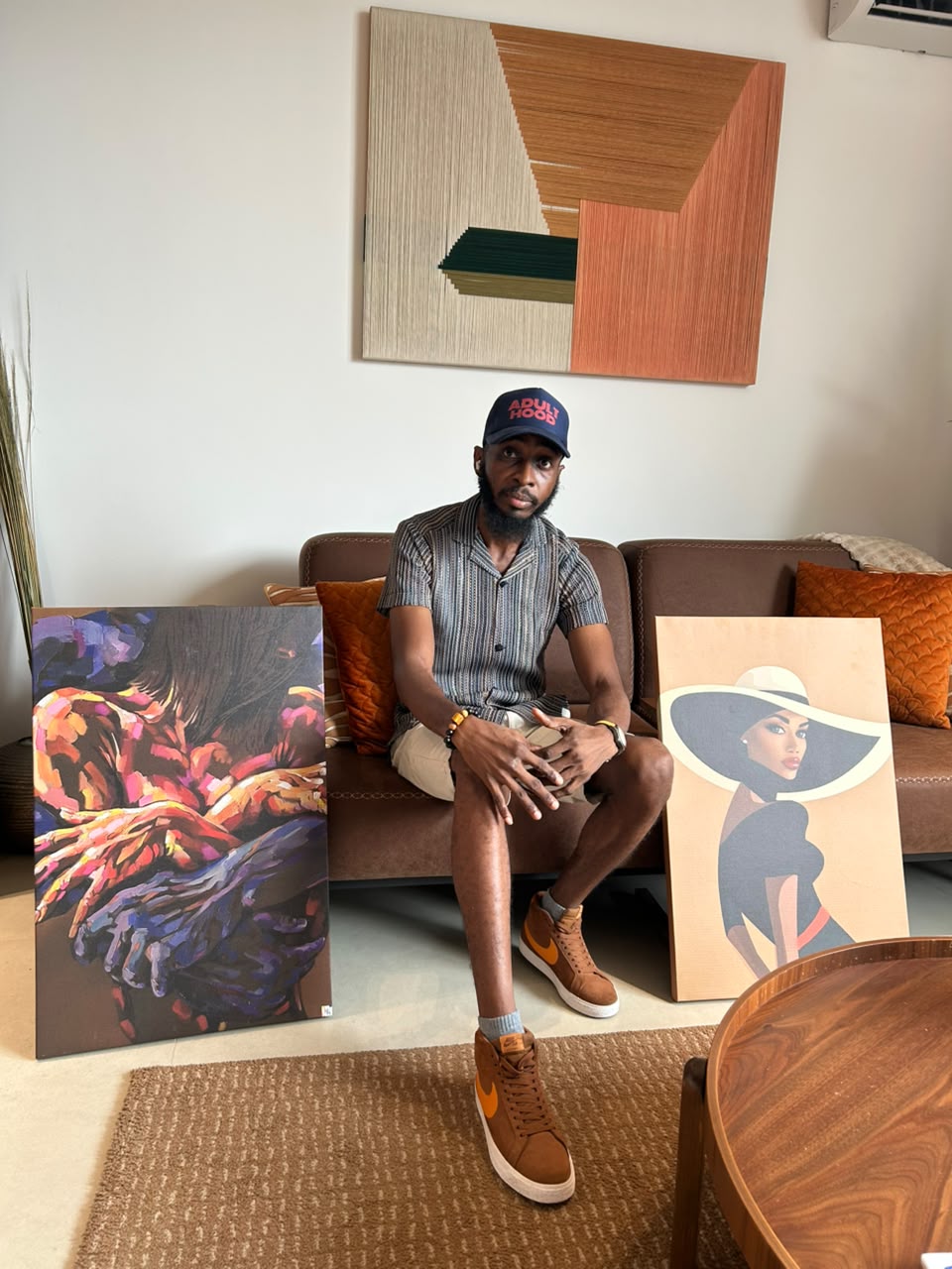 Maurice Zordeh seated between two of his canvases.